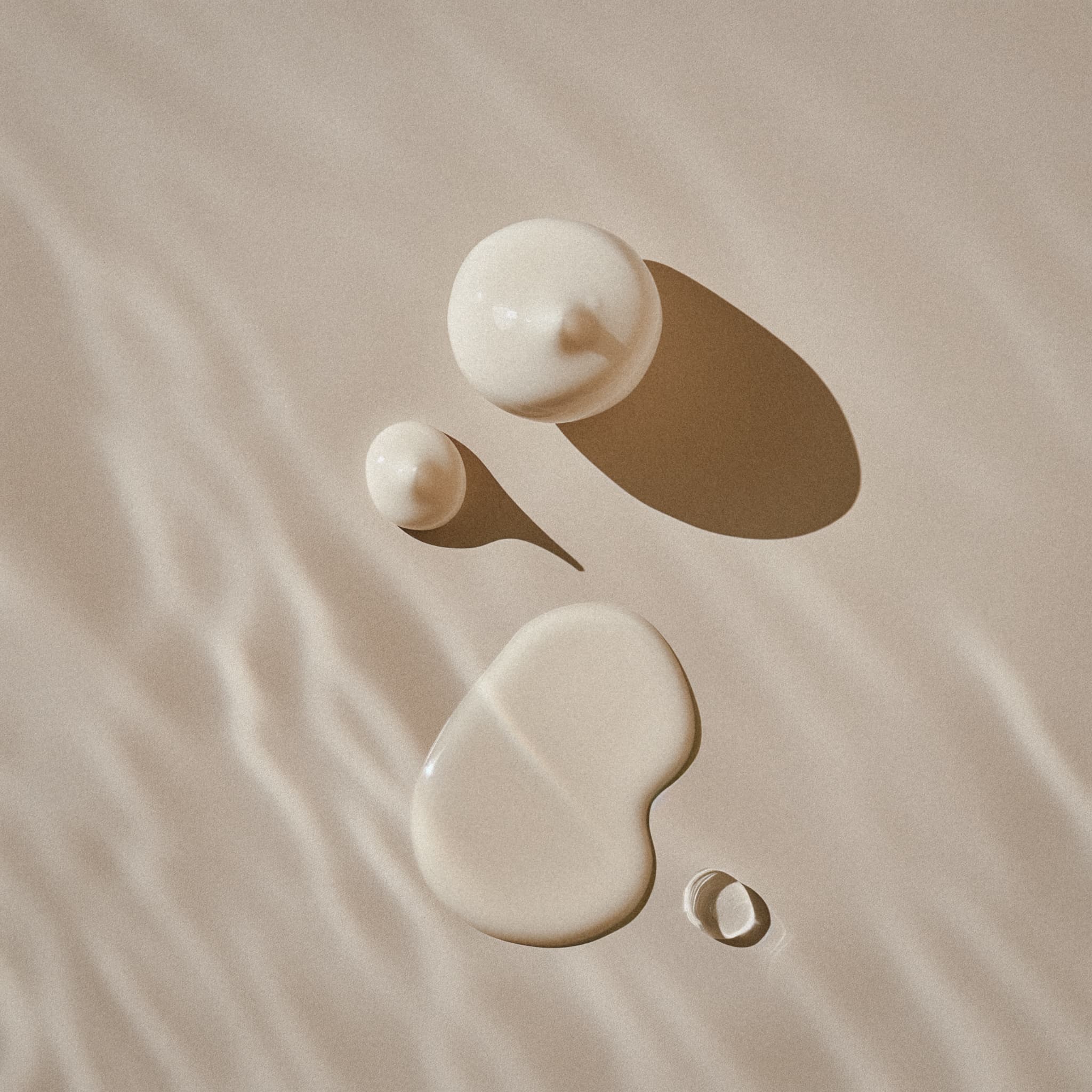 Skincare drops on beige surface representing precision and purity