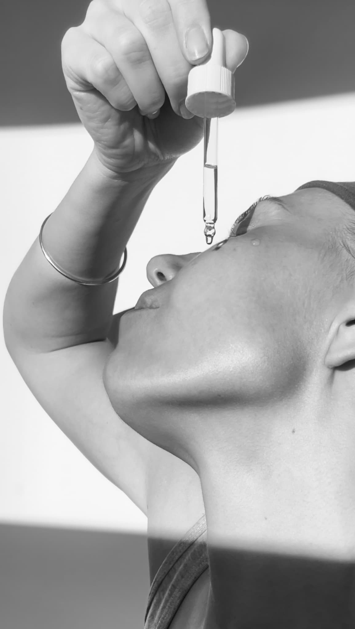 Close-up of a serum dropper being applied to the face